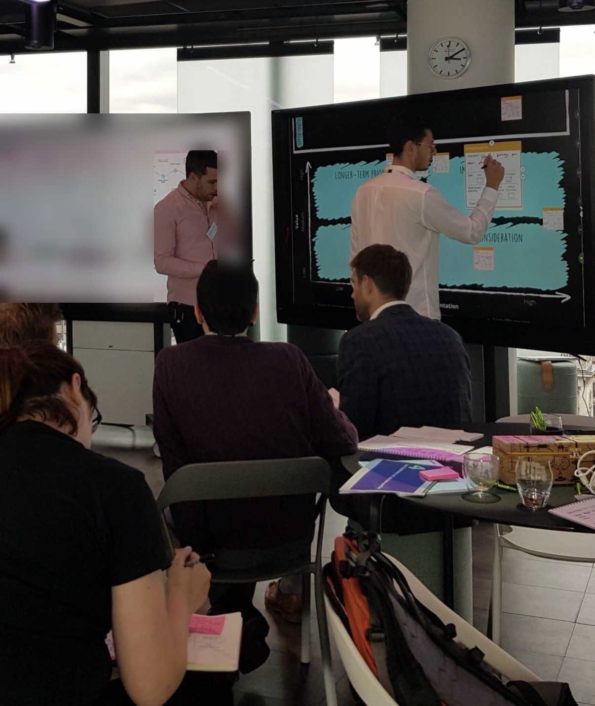 Delegates working through an exercise on large screens during a workshop